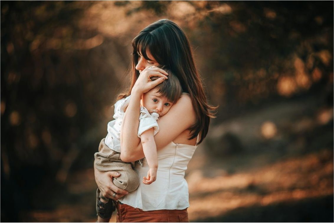 Mère portant son bébé contre elle, dans une lumière douce